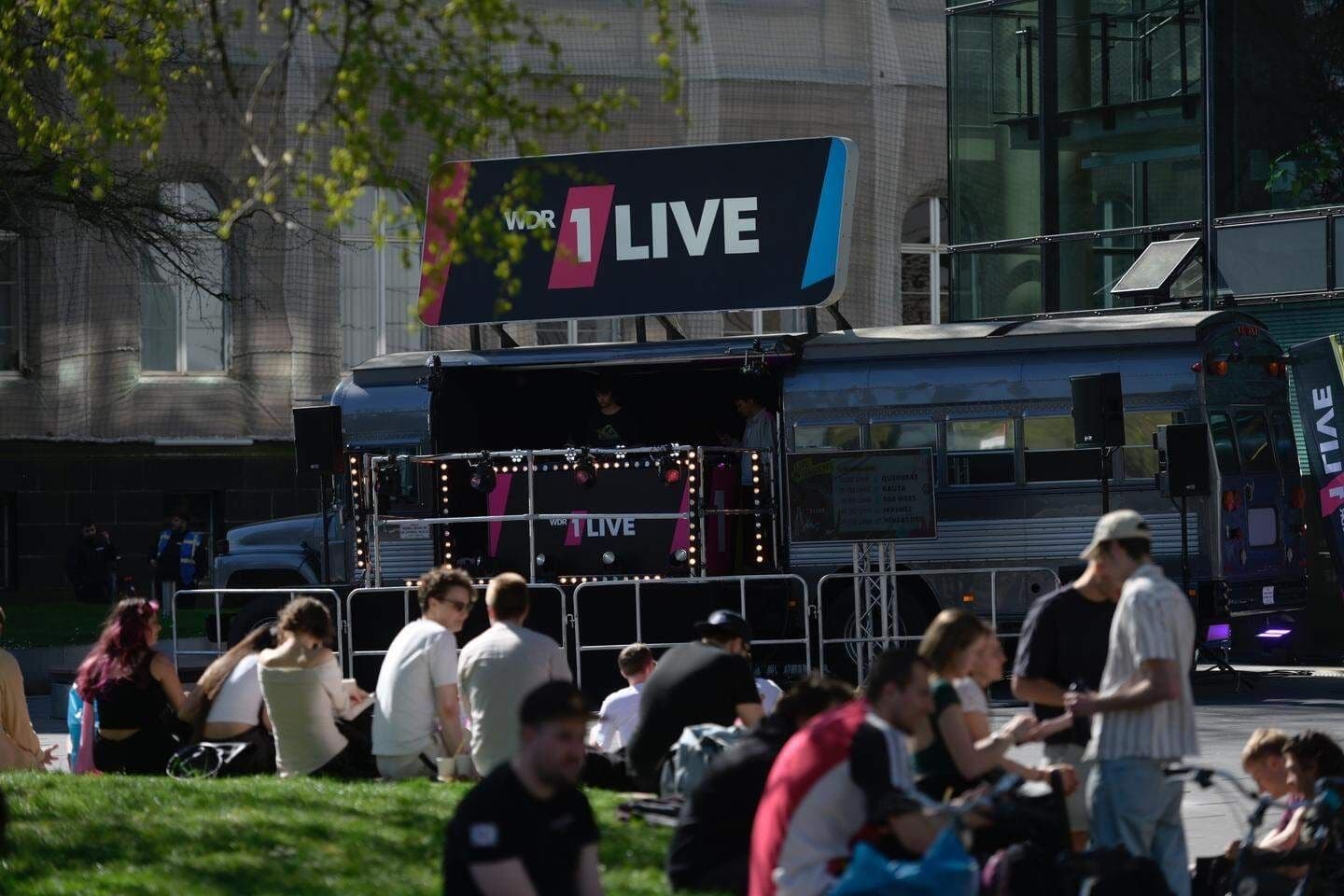 Menschen sitzen auf einer Wiese vor 1Live. | Bildquelle: Stefan Middenberger  Menschen sitzen auf einer Wiese vor 1Live.