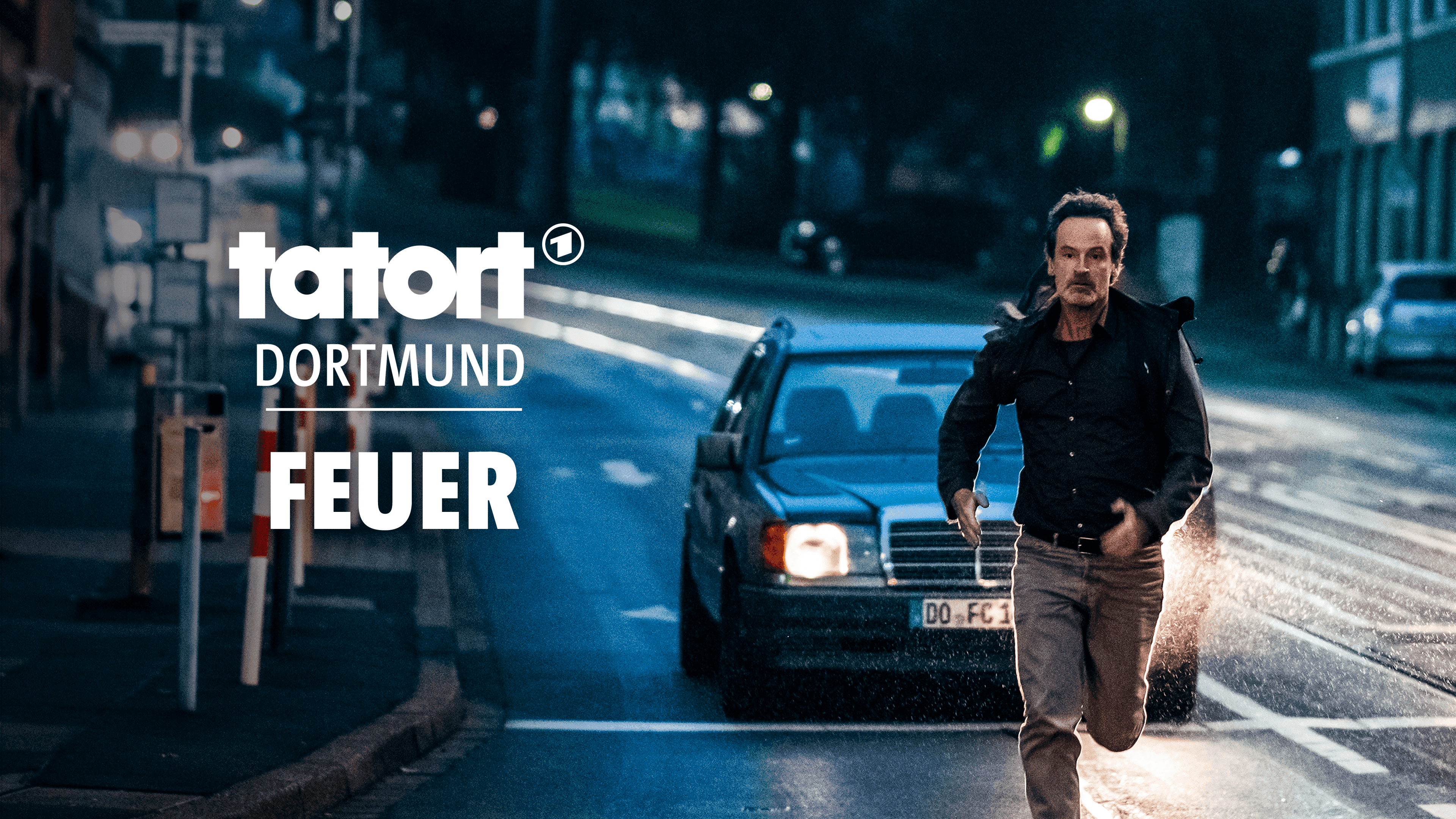 Ein Schauspieler rennt auf der Straße und wird von einem Auto verfolgt. Die Worte tatort Dortmund Feuer sind abgebildet.  | Bildquelle: WDR mediagroup GmbH Ein Schauspieler rennt auf der Straße und wird von einem Auto verfolgt. Die Worte tatort Dortmund Feuer sind abgebildet.